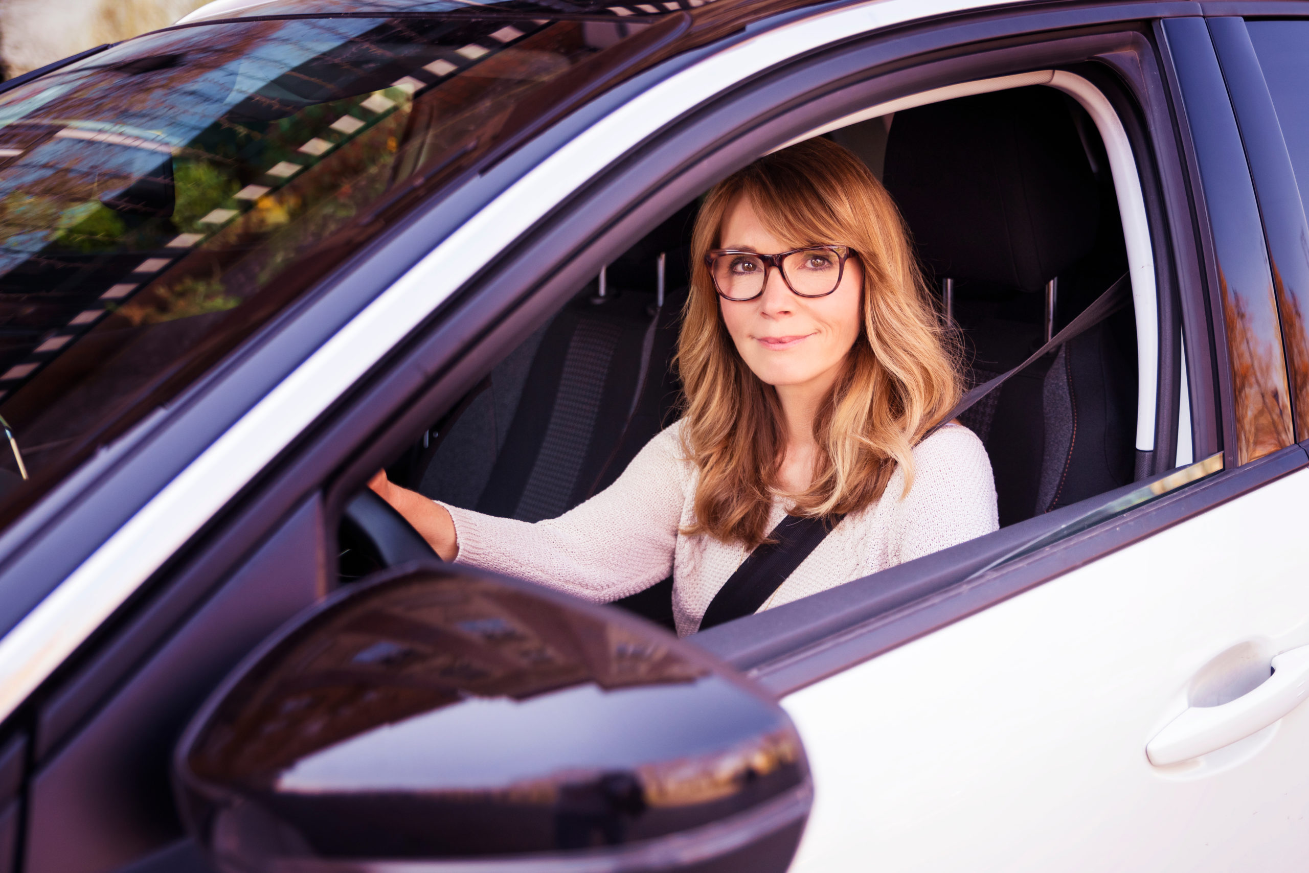 donna sorridente nella sua auto