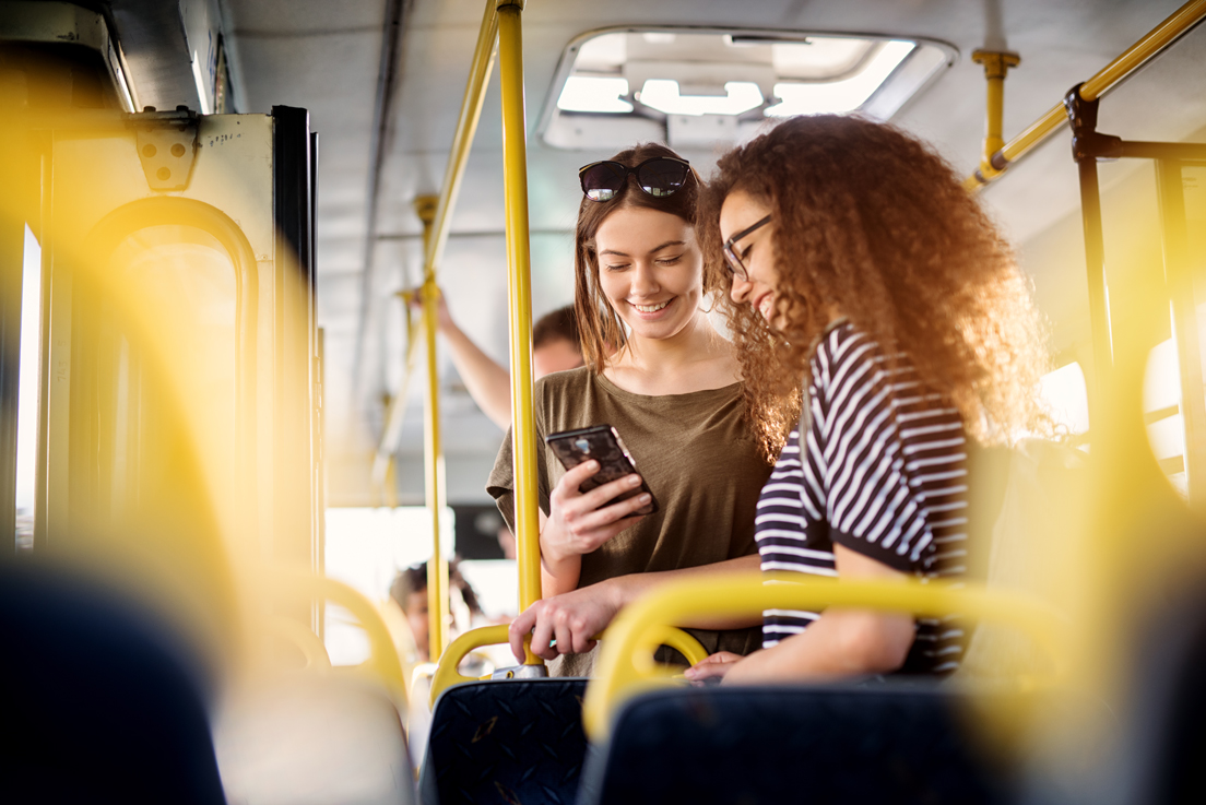 Amiche che guardano smartphone sull'autobus